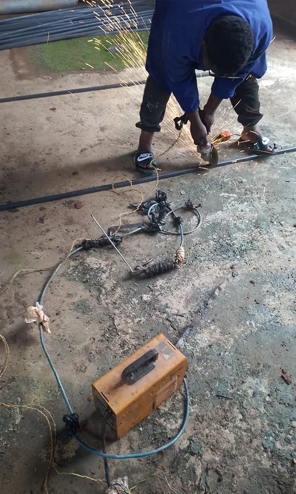 Square tubing cutting during fabrication of Goodwill hardware signage frames in Kampala
