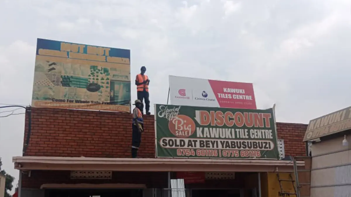 Installation team working high above the frontage at Kawuki Tile Centre • Gayaza for the Goodwill and Crown Crane rollout