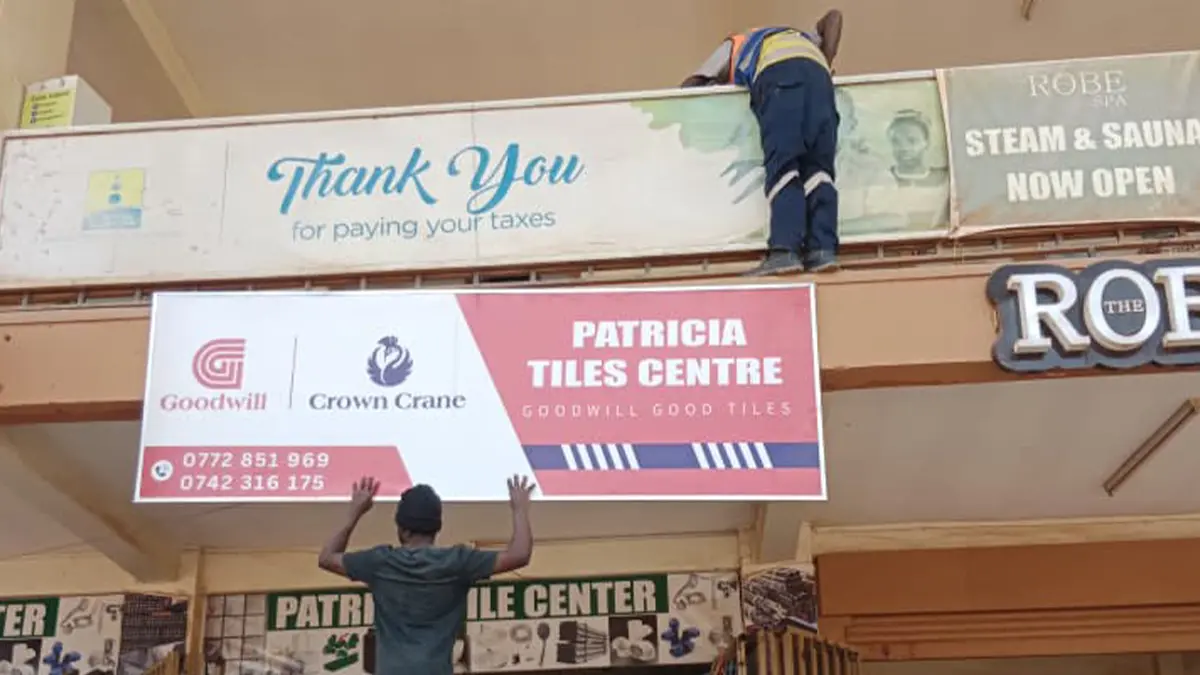 Framed sign during mounting at Patricia Tiles Centre • Kyaliwajjala for the Goodwill and Crown Crane rollout