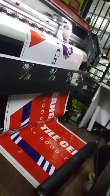 Goodwill and Crown Crane hardware signage running through a large-format printer in Kampala
